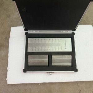 Hình ảnh bộ thước đo độ mịn sơn 0–50µm gồm tấm đo bằng kim loại có vạch chia rõ ràng, dao gạt đi kèm và hộp đựng bảo quản chắc chắn. Sản phẩm sử dụng để kiểm tra độ mịn, mức độ phân tán của sơn, mực in, chất phủ và các vật liệu dạng lỏng có chứa hạt phân tán.