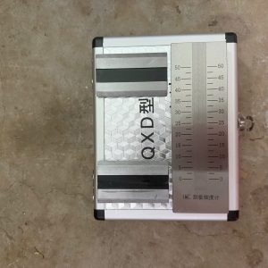 Thước đo độ mịn sơn 0–50µm dạng tấm kim loại chính xác, kèm dao gạt và hộp đựng bảo quản chuyên dụng.